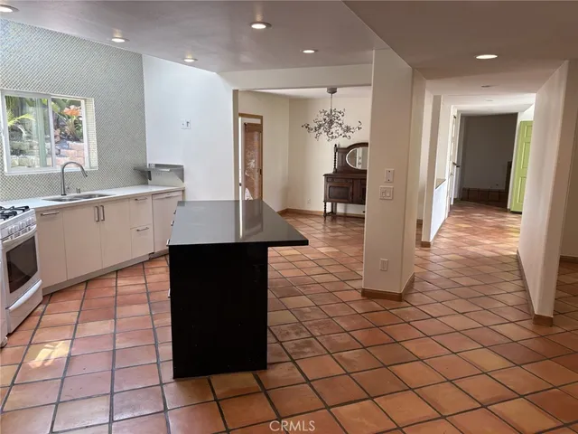a view of a kitchen with kitchen island granite countertop a refrigerator and a sink