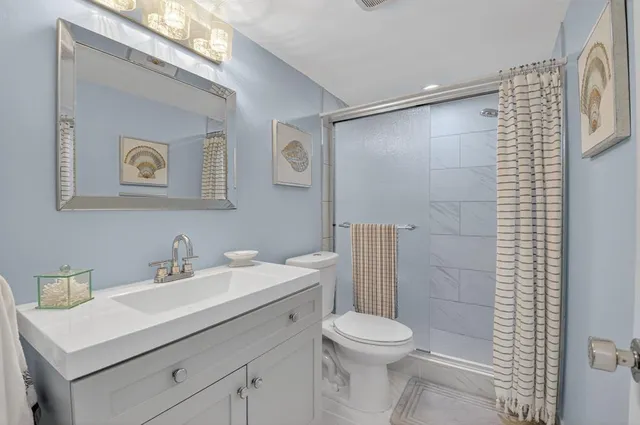 a bathroom with a sink mirror toilet and shower