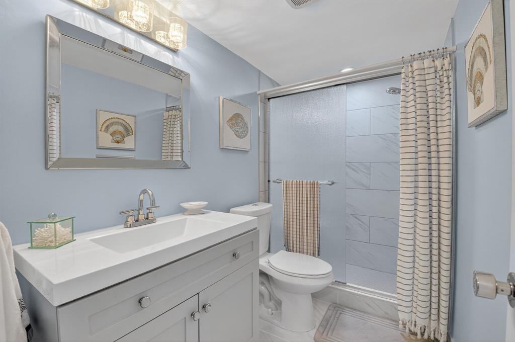 2601 Northeast 3rd Street, Unit 403 Boynton Beach, FL 33435 - Photo 14 of 33 a bathroom with a sink mirror toilet and shower