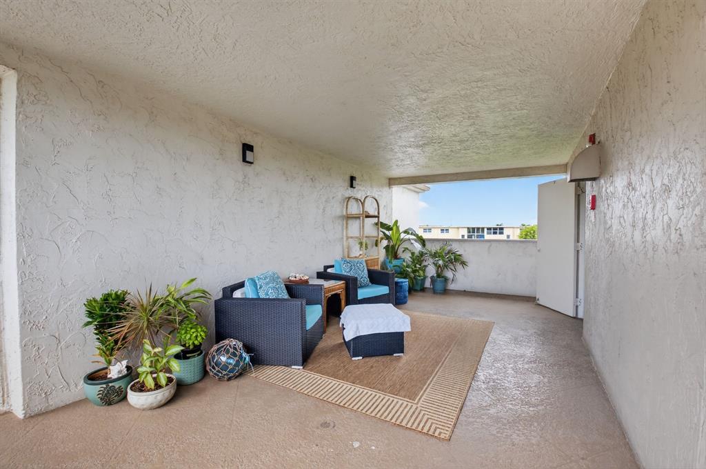2601 Northeast 3rd Street, Unit 403 Boynton Beach, FL 33435 - Photo 19 of 33 a hallway with a couch and a potted plant