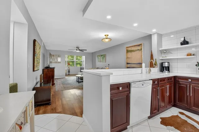 a kitchen with kitchen island granite countertop a sink counter top space and living room view