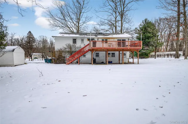 a view of a white house with a large tree in front of a house