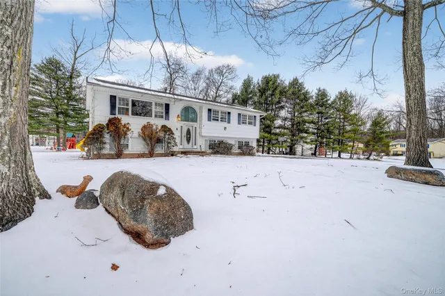 a view of a white house with a yard covered in snow