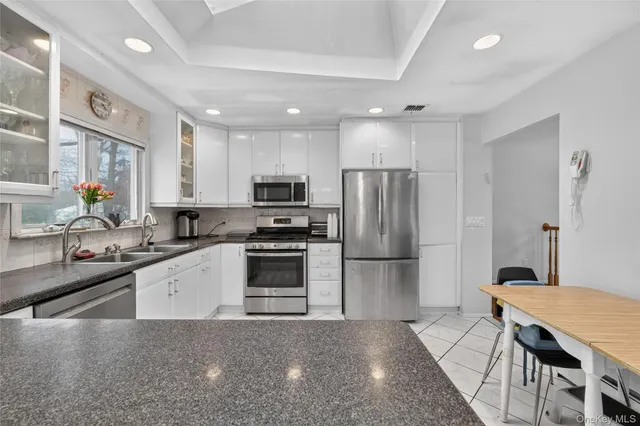 a kitchen with stainless steel appliances a refrigerator sink stove microwave and cabinets