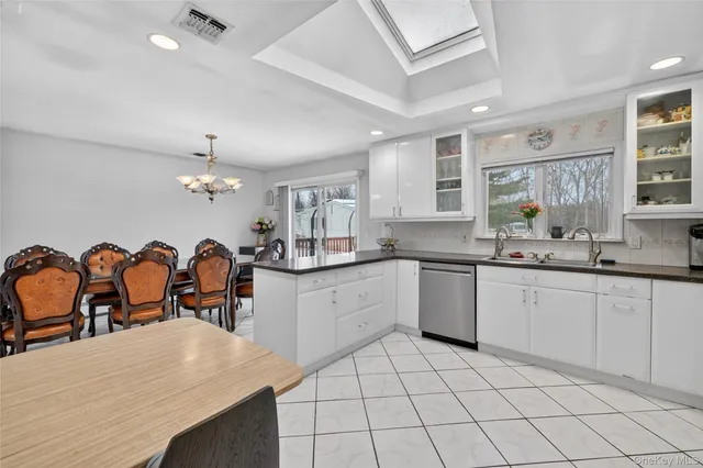 a kitchen with granite countertop cabinets a dining table and appliances