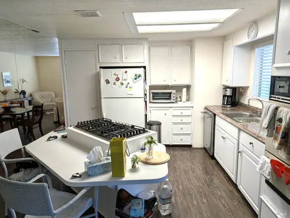 a kitchen with a stove a table and chairs in it