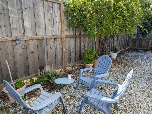 a backyard of a house with chairs and a table