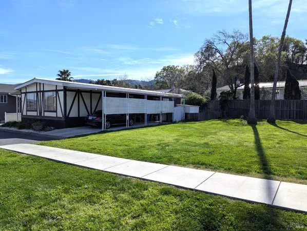 a view of a house with a yard and sitting area