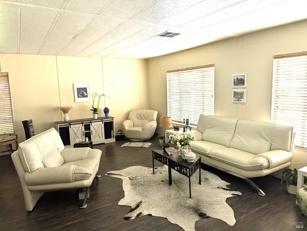 a living room with furniture wooden floor and a large window