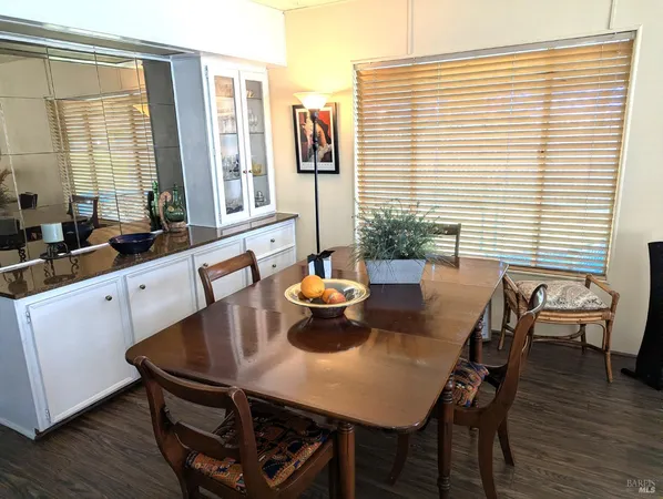a kitchen with a table chairs and wooden floor