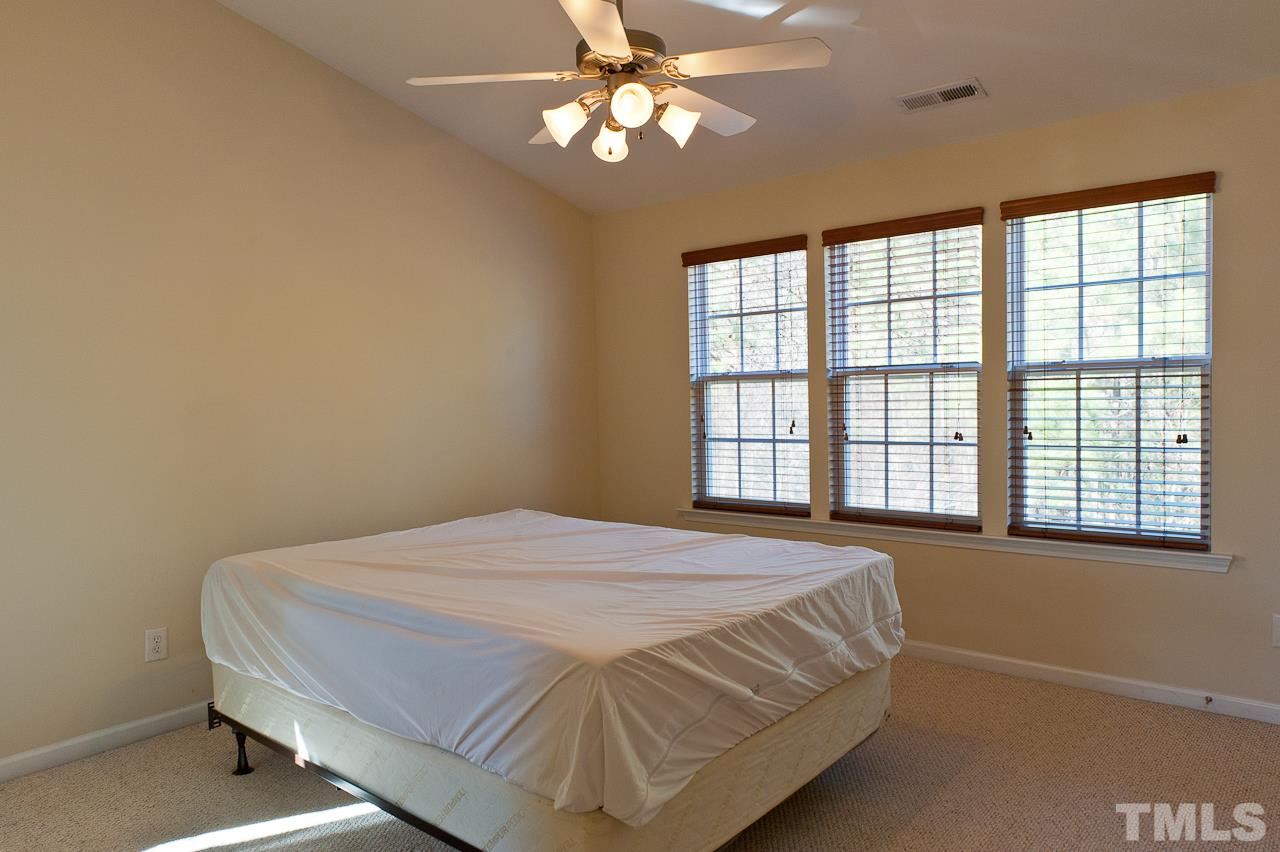 7874 Spungold Street Raleigh, NC 27617 - Photo 11 of 18 a bedroom with a bed and a window