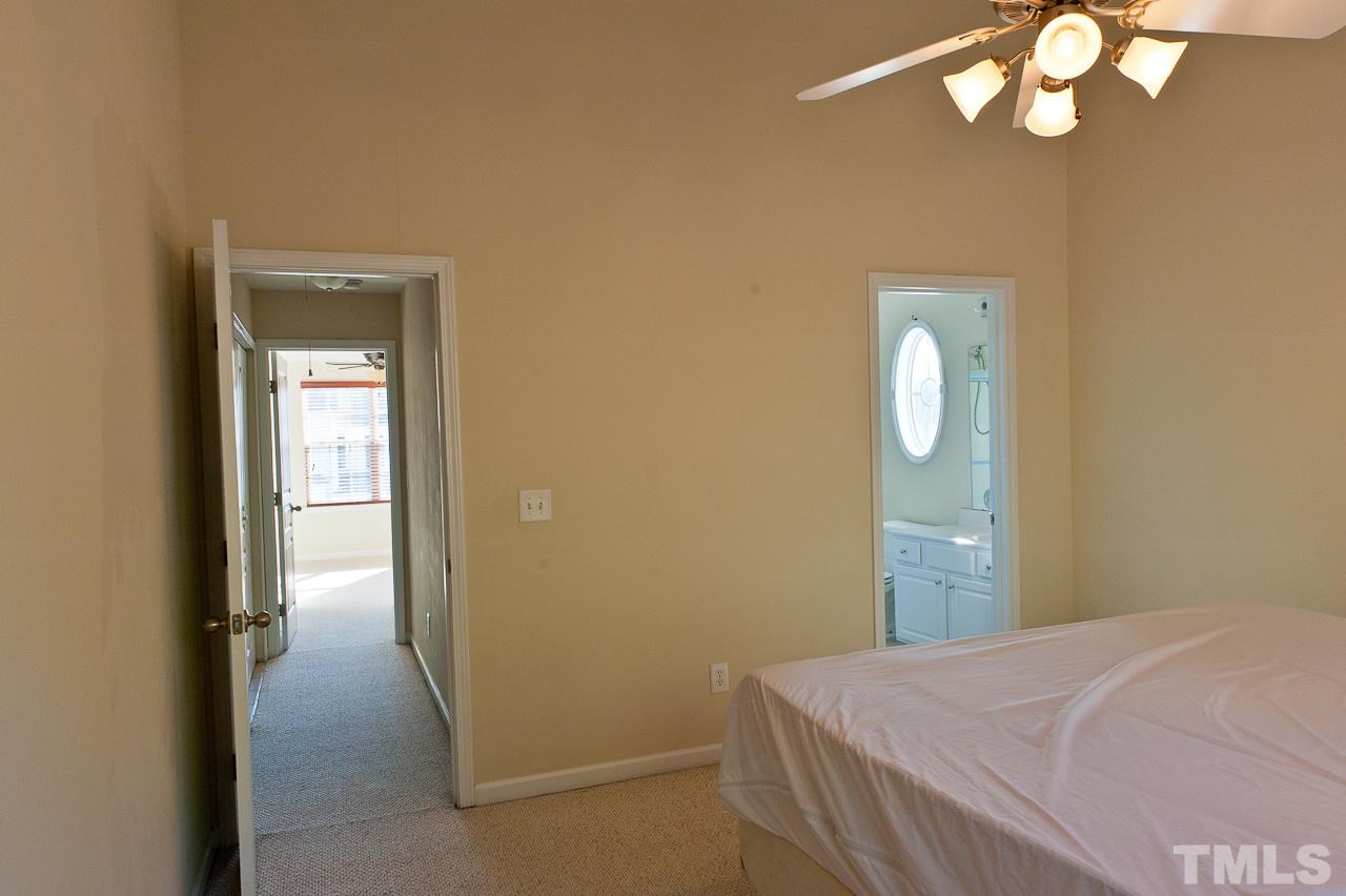 7874 Spungold Street Raleigh, NC 27617 - Photo 12 of 18 a bedroom with a bed and cabinets