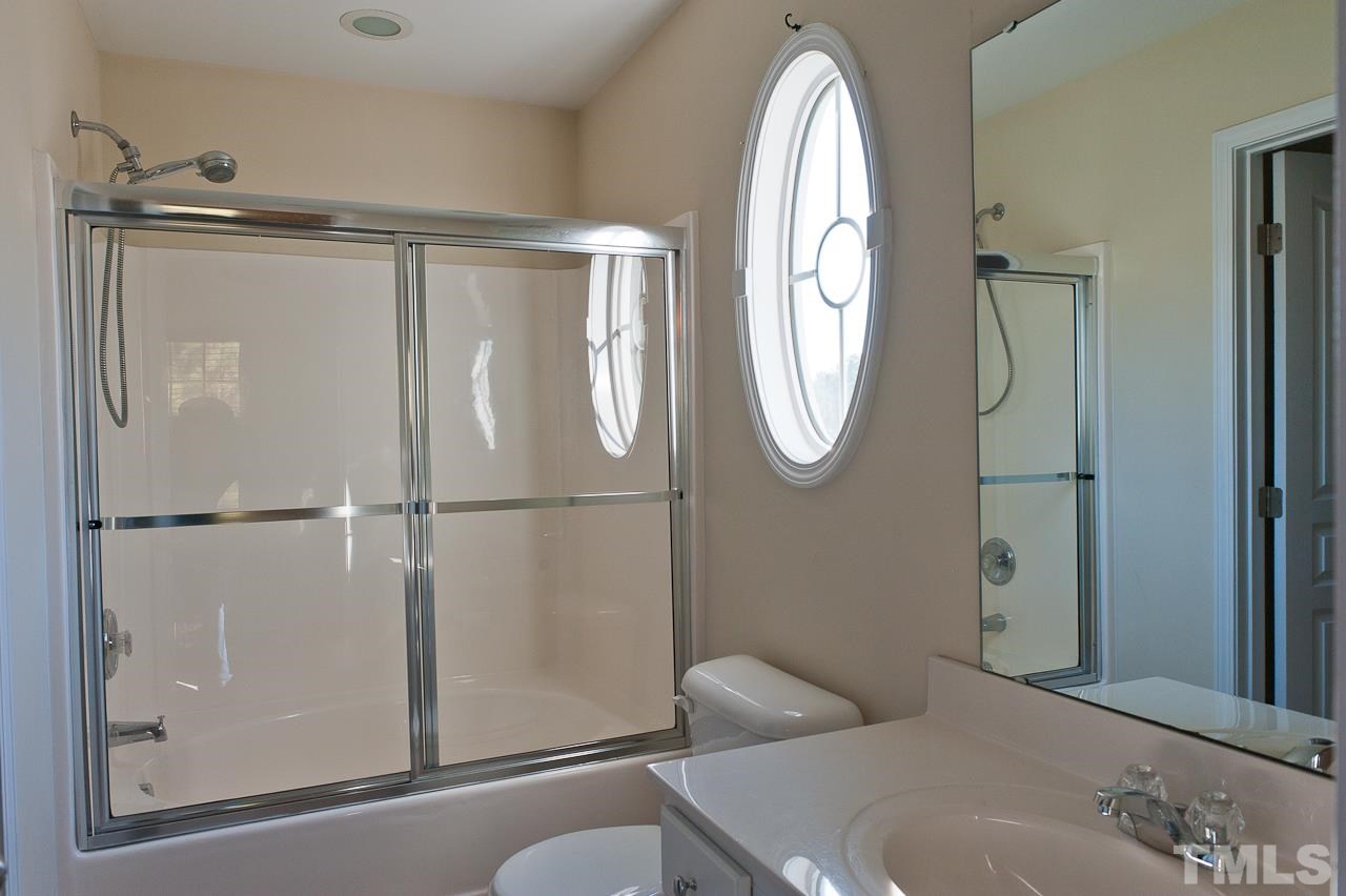 7874 Spungold Street Raleigh, NC 27617 - Photo 13 of 18 a bathroom with a toilet a sink and a mirror
