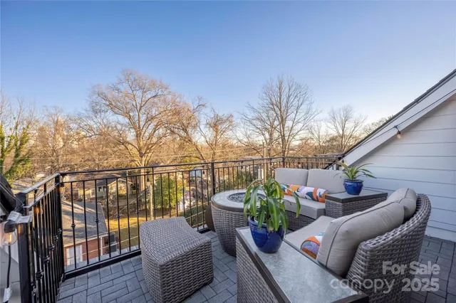 a view of a patio on the roof deck with wooden fence