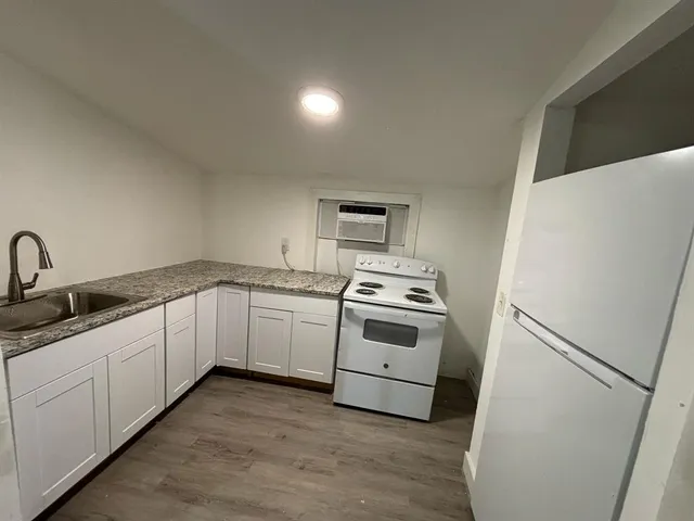 a kitchen with white cabinets and white appliances