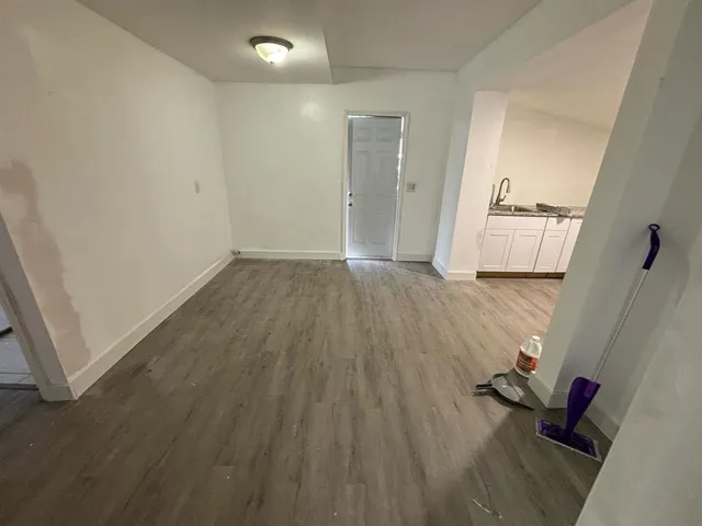 an empty room with wooden floor and a window