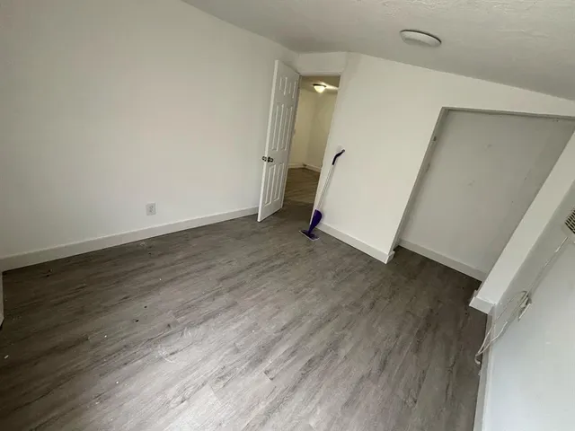 an empty room with wooden floor and stairs