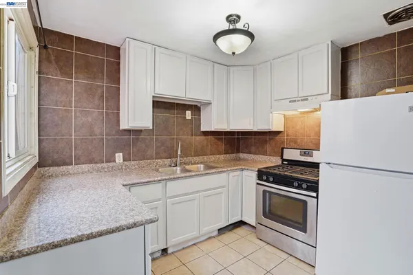 a kitchen with a sink cabinets and white appliances