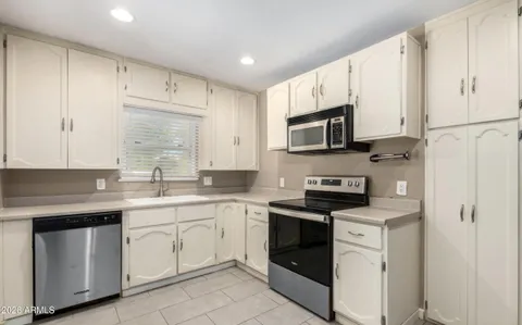 a kitchen with white cabinets stainless steel appliances and sink