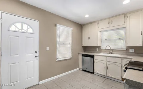 a kitchen with a sink cabinets and window