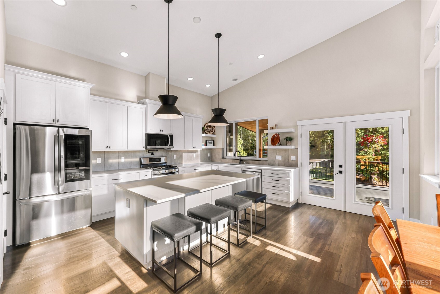 322 Manley Road Bellingham, WA 98229 - Photo 8 of 40 a kitchen with stainless steel appliances kitchen island granite countertop a refrigerator a stove a kitchen island a dining table and chairs with wooden floor