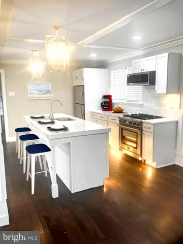 a kitchen with a stove a sink and a refrigerator