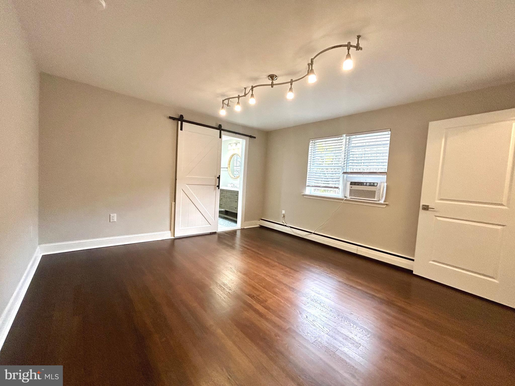 381 Upper Gulph Road Wayne, PA 19087 - Photo 8 of 17 an empty room with wooden floor chandelier and windows