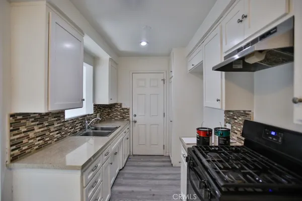 a kitchen with a stove and a wooden cabinets