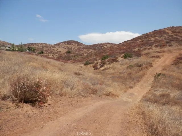 a view of a dry yard with mountains in the background