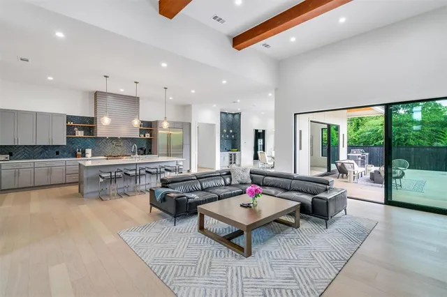 a living room with stainless steel appliances kitchen island furniture and a wooden floor