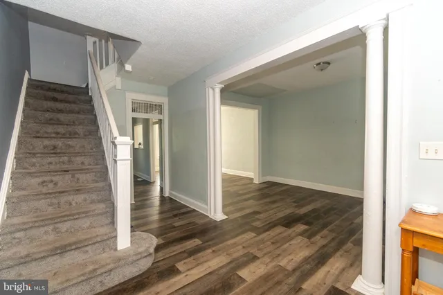 a view of a hallway with wooden floor and staircase
