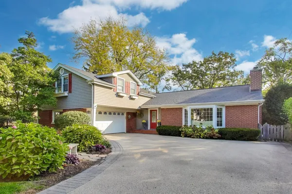 a front view of a house with a yard and outdoor seating