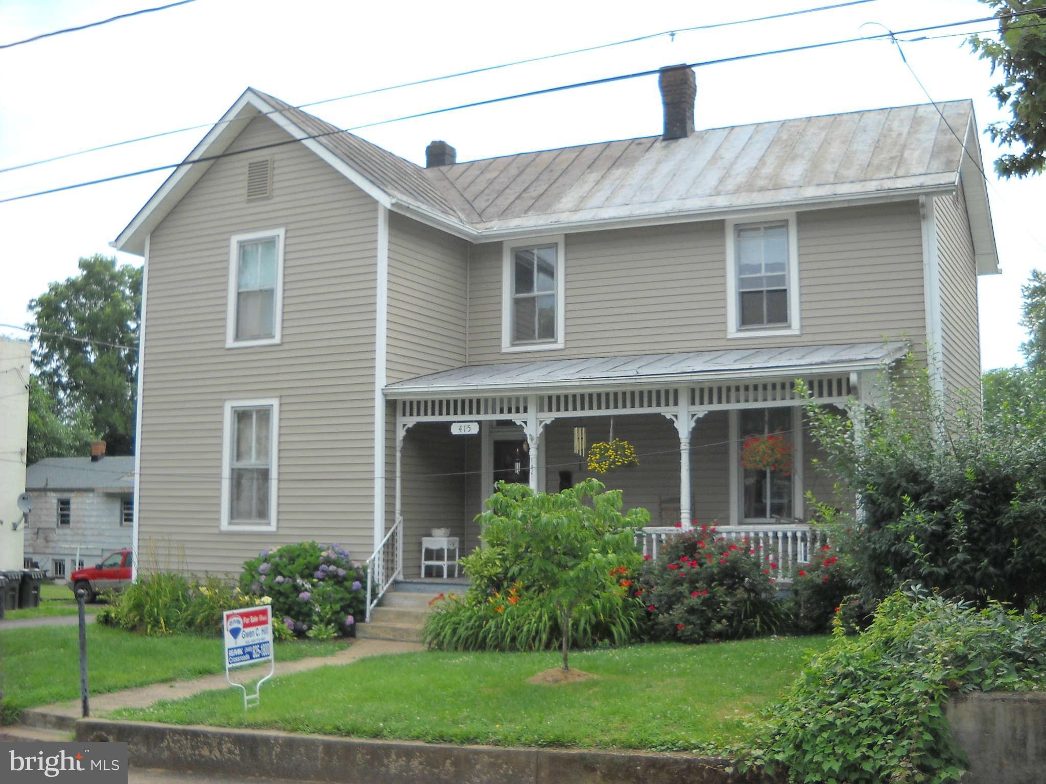 a front view of a house with a garden and plants