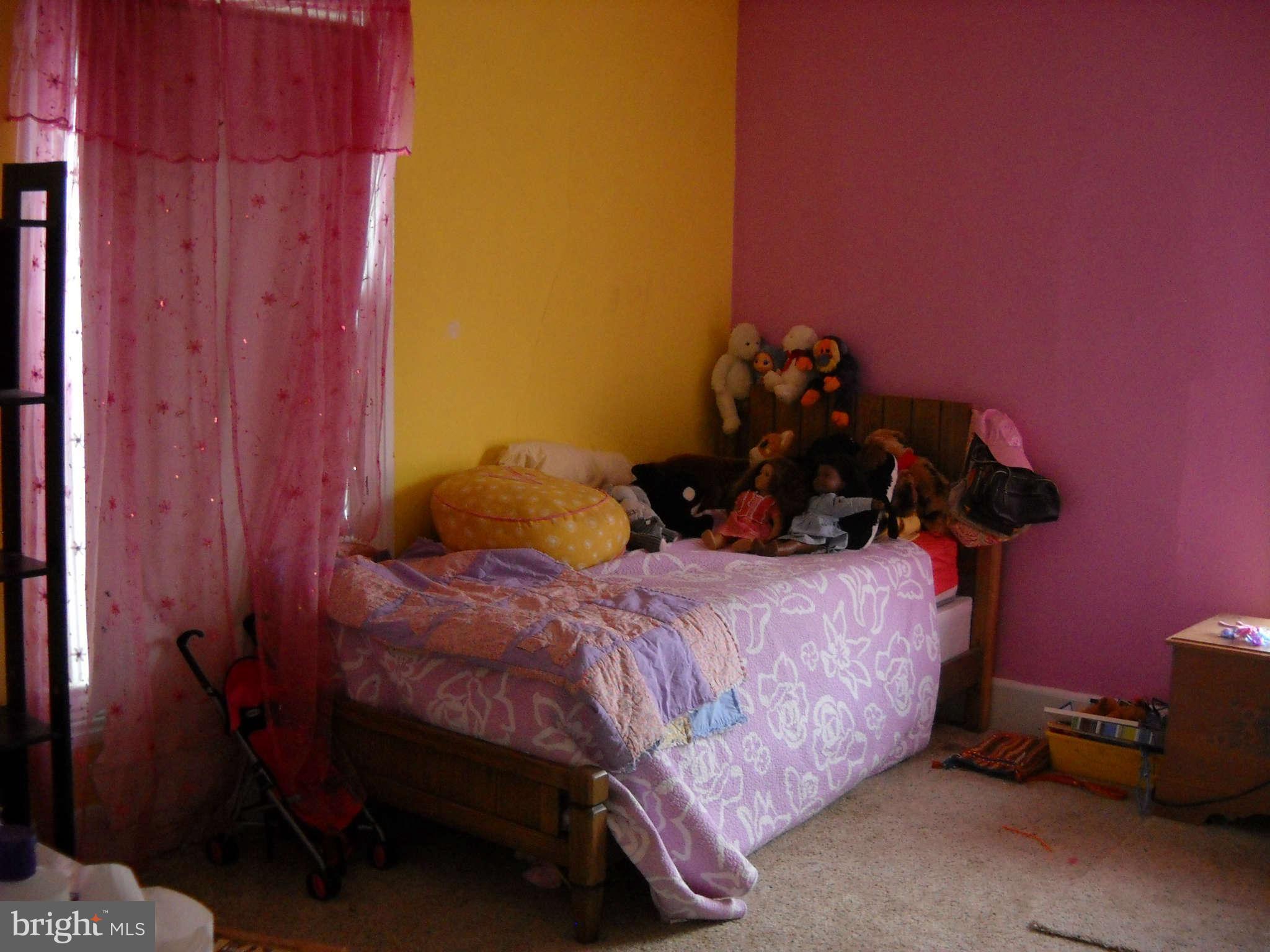 415 Hill Street Culpeper, VA 22701 - Photo 12 of 14 a bed sitting in a bedroom next to a wooden door