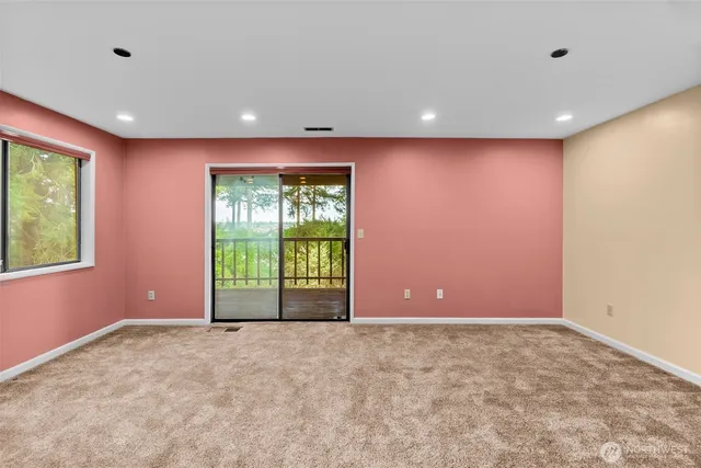 a view of an empty room with a fireplace and a window