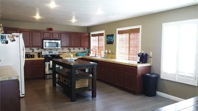 a kitchen with granite countertop a sink appliances and cabinets