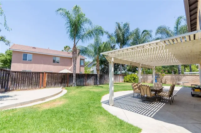 a view of a patio with a table chairs and a swimming pool