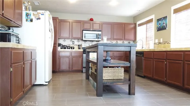 a kitchen with stainless steel appliances granite countertop a refrigerator and a stove top oven
