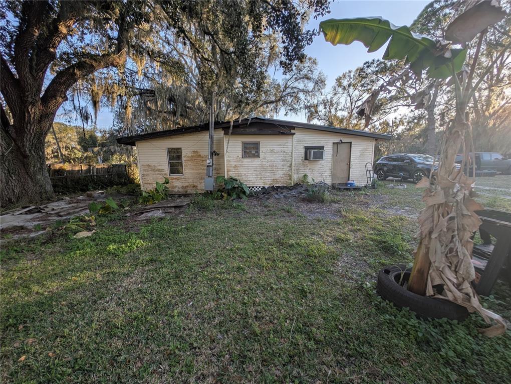 2516 Hebb Road Auburndale, FL 33823 - Photo 48 of 55 a backyard of a house with large trees and brick wall