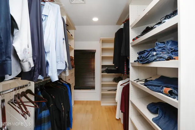a view of walk in closet with clothes and shoes