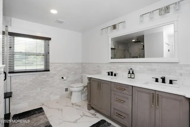 a bathroom with a toilet sink and mirror
