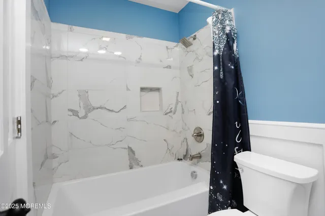 a bathroom with a bathtub and toilet