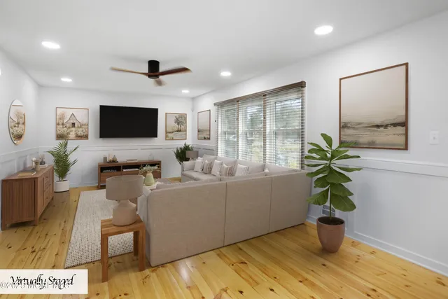 a living room with furniture a flat screen tv and a potted plant