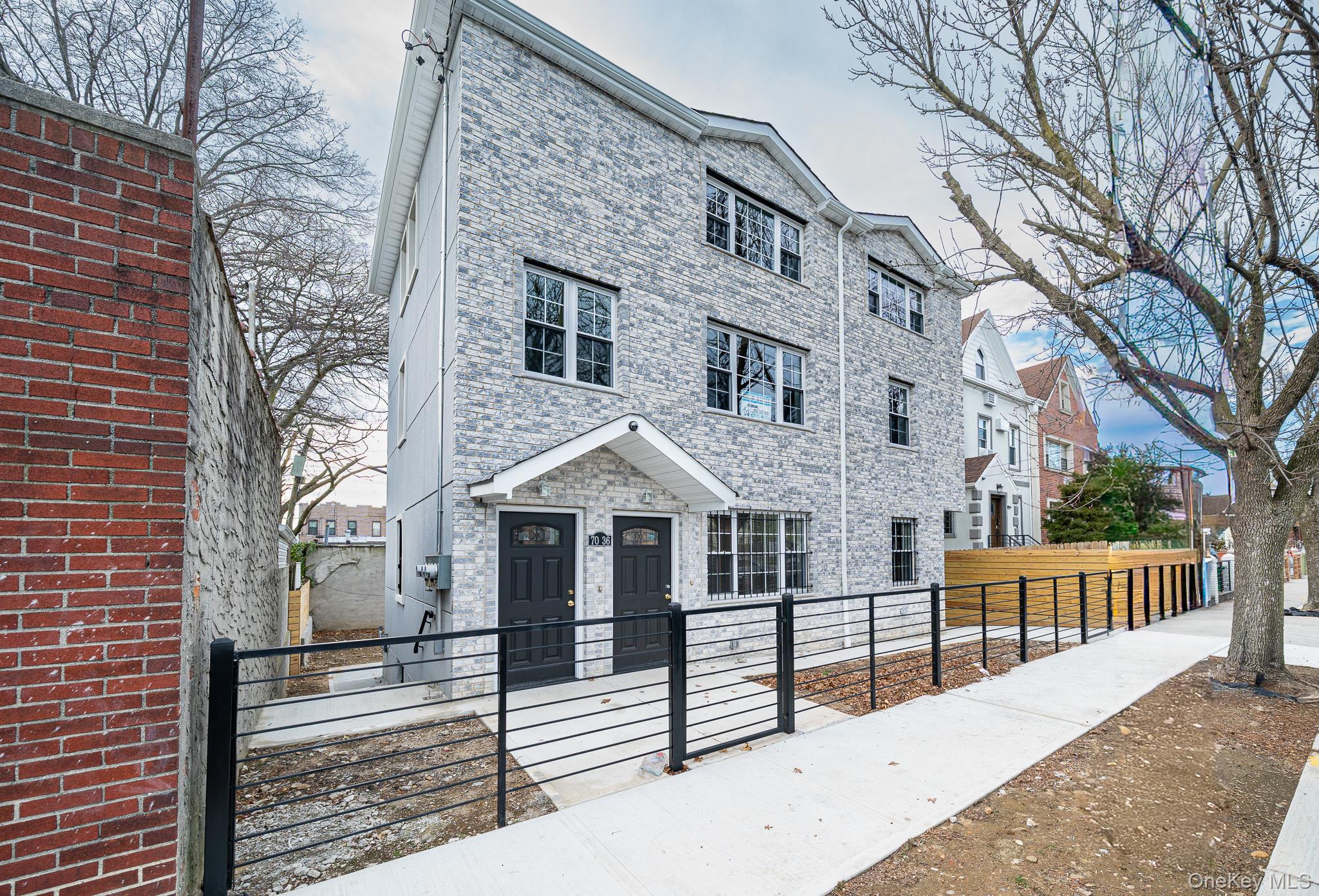70-36 70th Street Queens, NY 11385 - Photo 1 of 29 View of front facade featuring a fenced front yard, a gate, and brick siding