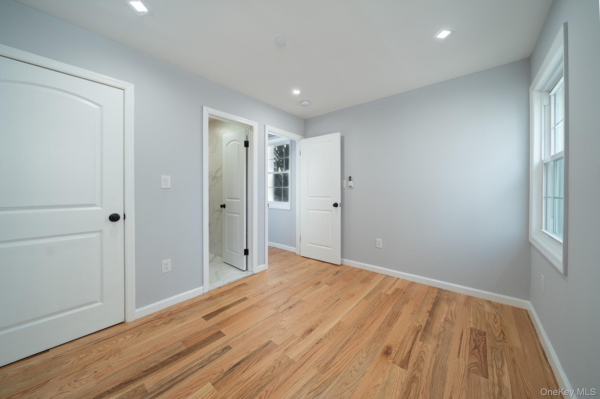 70-36 70th Street Queens, NY 11385 - Photo 10 of 29 Unfurnished bedroom with light wood finished floors, ensuite bath, and recessed lighting