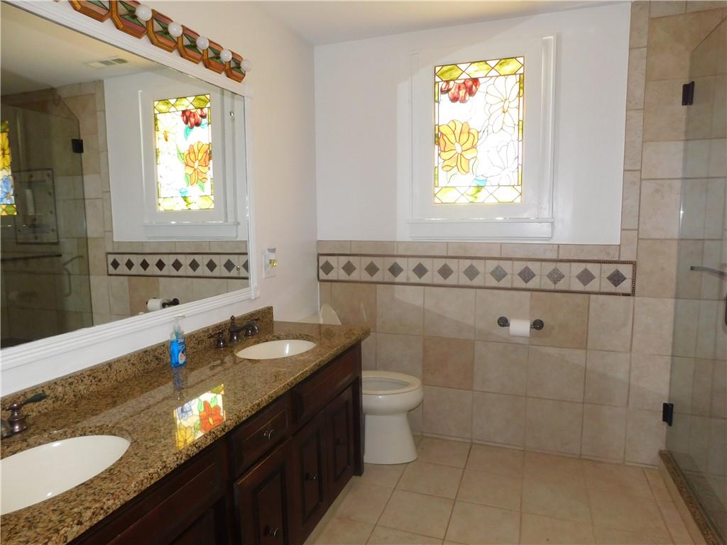 431 Old Rt 21 Road McClellandtown, PA 15458 - Photo 15 of 25 a bathroom with a granite countertop sink a toilet a mirror and a window
