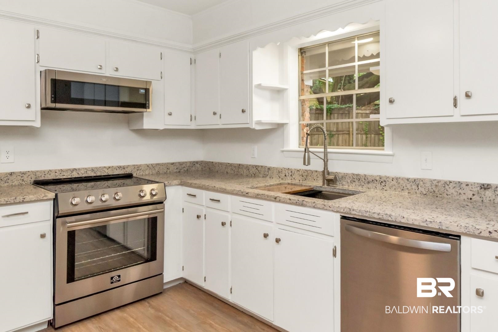 5217 Perin Road Mobile, AL 36693 - Photo 22 of 45 Kitchen featuring white cabinetry, light-toned countertops, wood-finish flooring, stainless steel appliances, and a window above the sink
