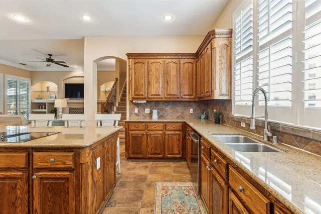 a kitchen with stainless steel appliances granite countertop a sink stove and cabinets