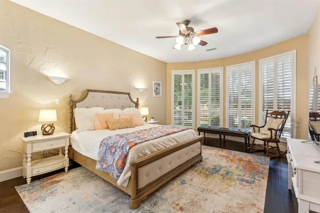a bedroom with a bed a large window and a chandelier