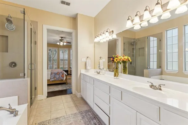 a spacious bathroom with a double vanity sink mirror and chandelier